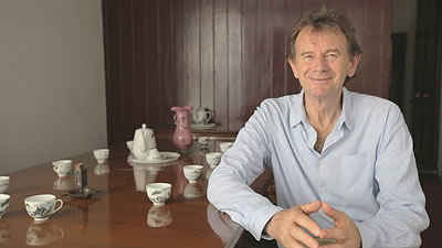 Michael Wood seated a table with tea cups and teapot