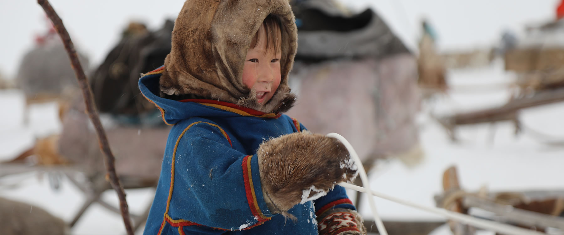 young child bundled up in warm clothing in snow