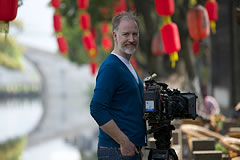 crew member with red lanterns and canal in background