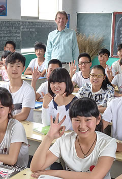 students seated at desks with Michael Wood standing behind them