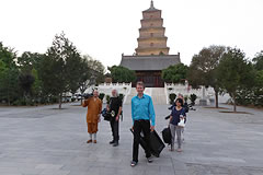 Michael Wood walking with film crew and monk in front of golden pagoda