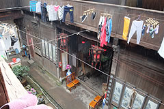 exterior view of old wooden house with laundry hanging from a line above teh front entrance